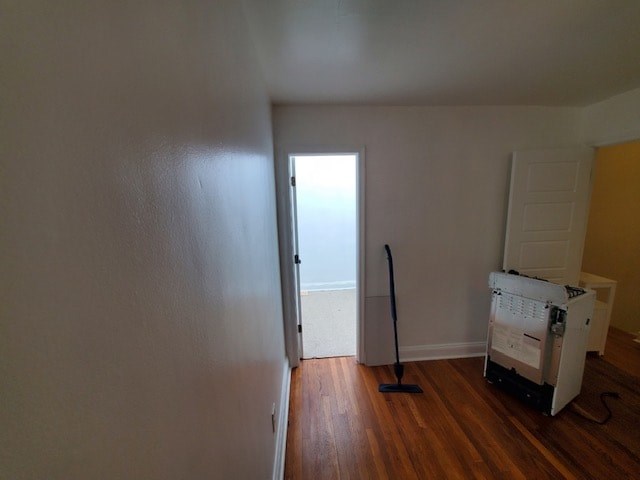 A room with a white wall and a wooden floor.
