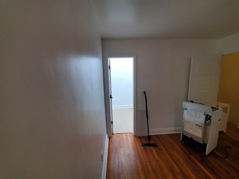 A room with a white wall and a wooden floor.
