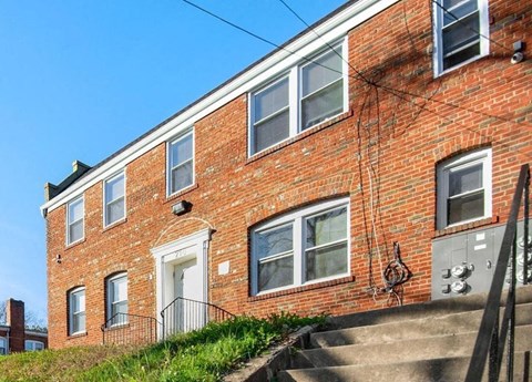 a brick apartment building with a white door and stairs