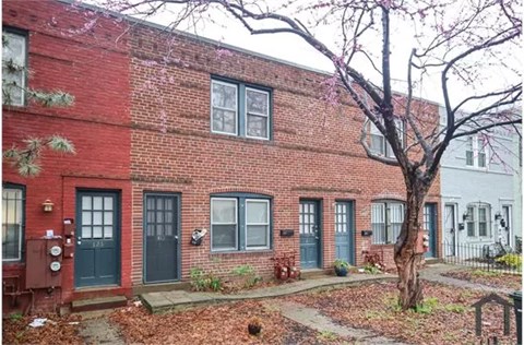 A red brick building with green doors and windows.