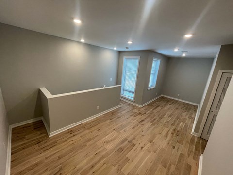 a living room with wood floors and grey walls and a window
