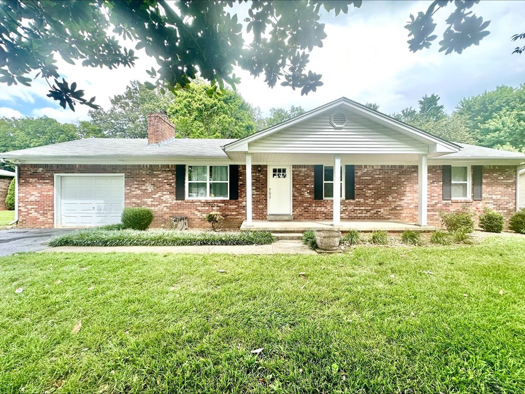 a small brick house with a lawn in front of it