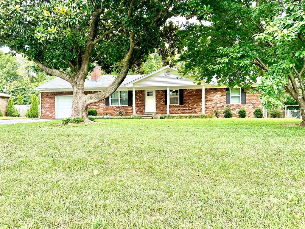 a house with a lawn and trees in front of it