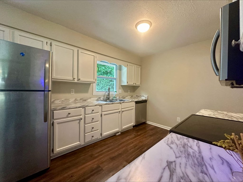 a kitchen with white cabinets and a stainless steel refrigerator