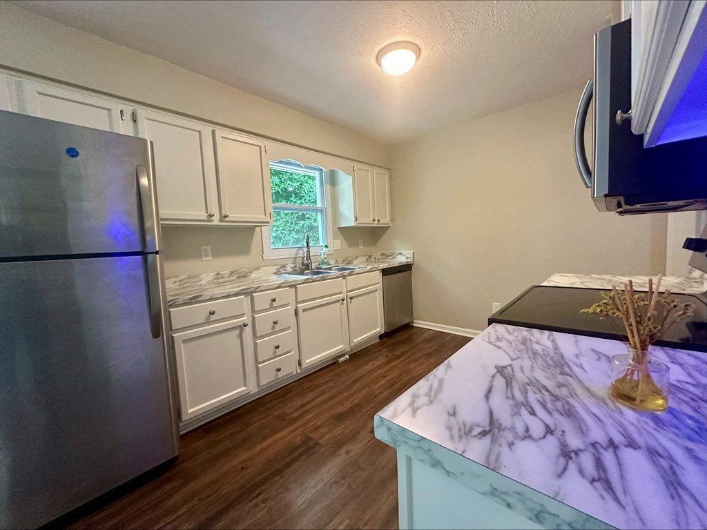 a kitchen with white cabinets and a stainless steel refrigerator