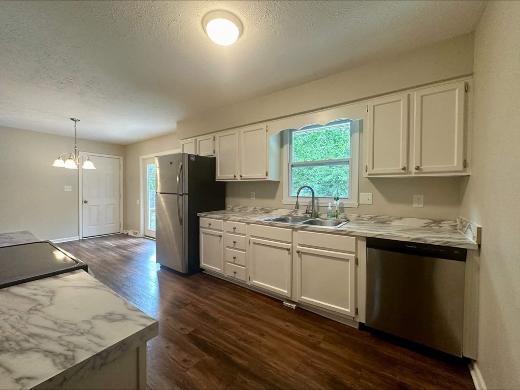 a kitchen with white cabinets and a stainless steel refrigerator