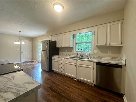 a kitchen with white cabinets and a stainless steel refrigerator