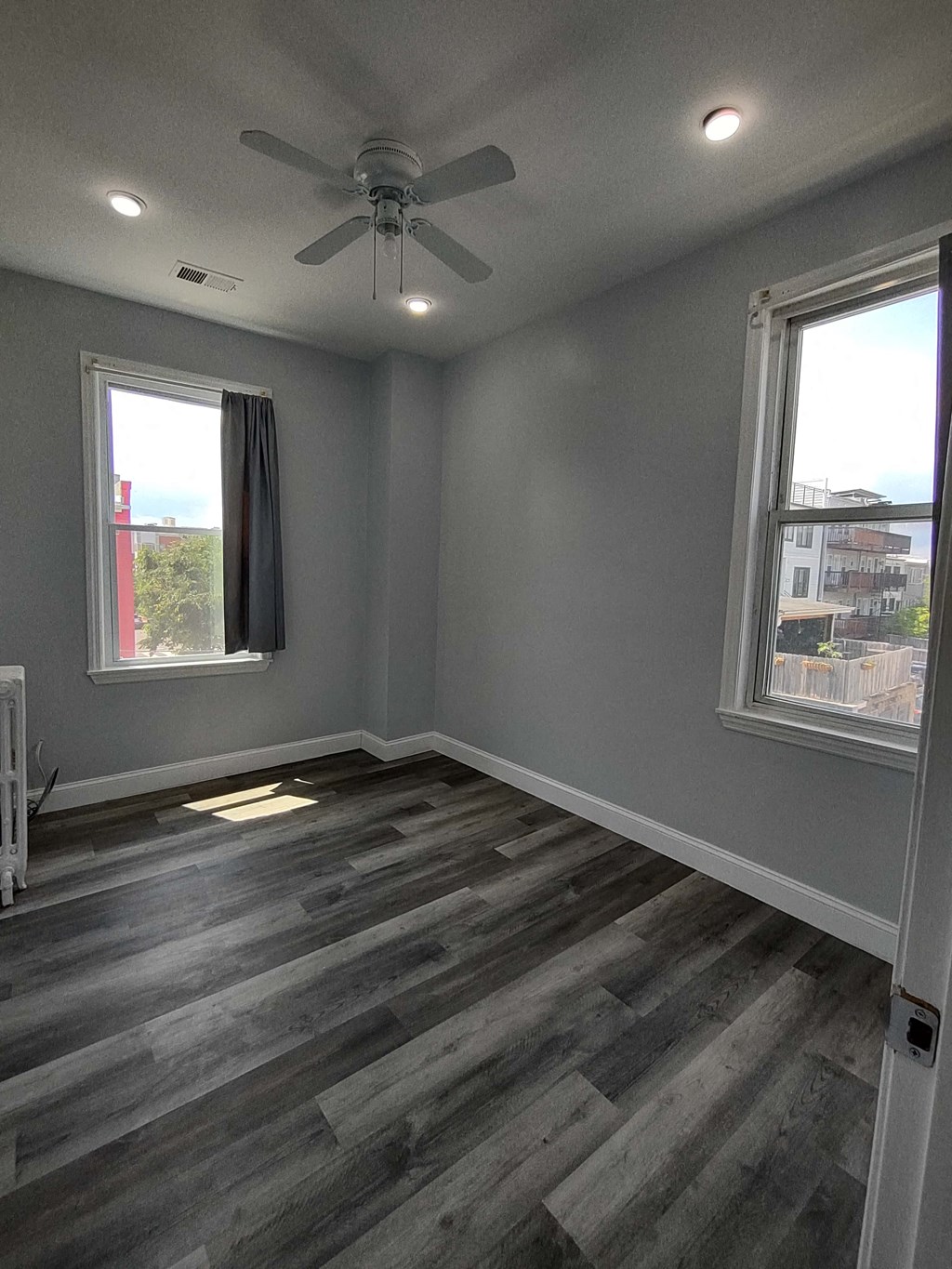 a living room with wood floors and a ceiling fan