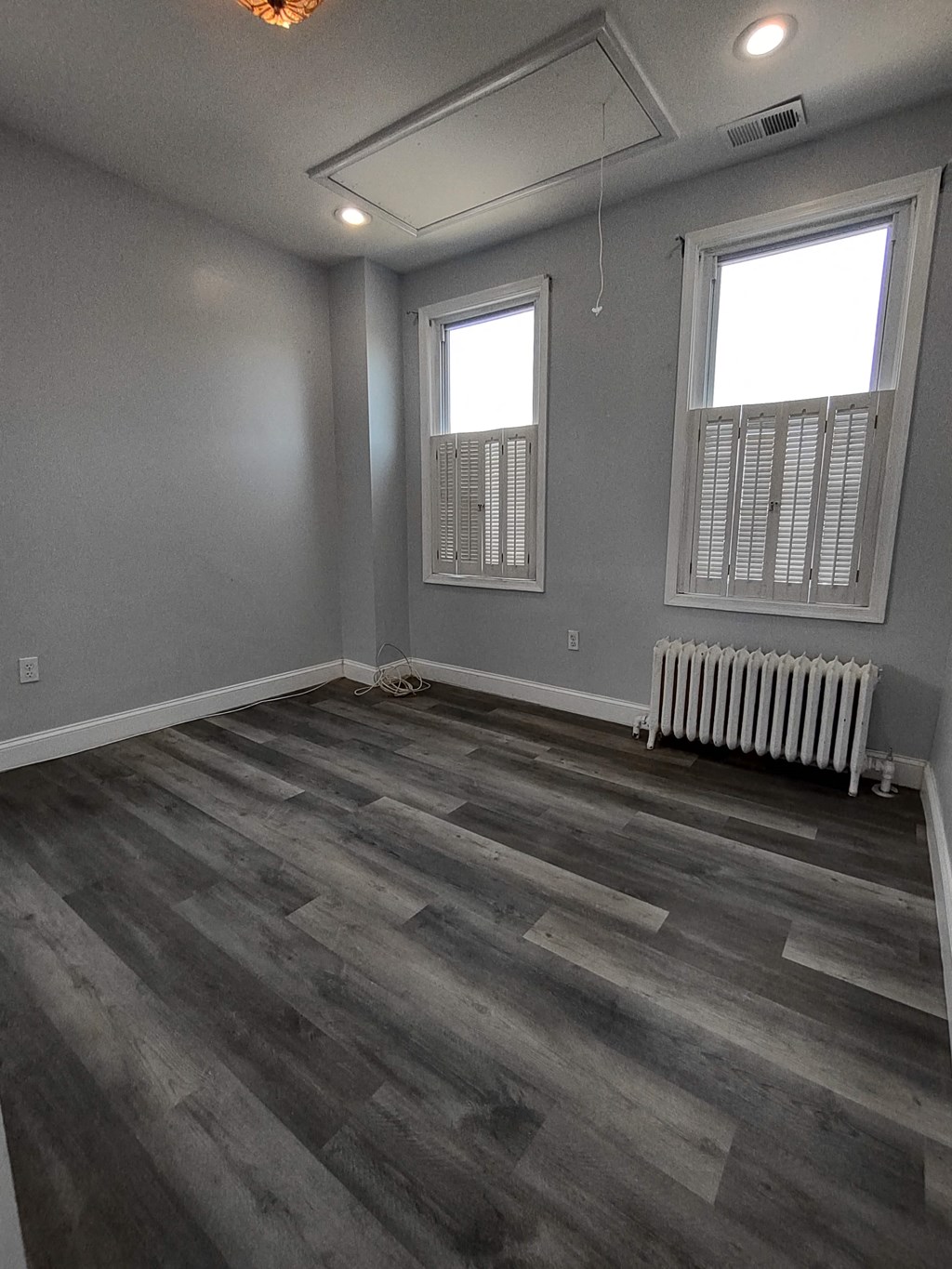 a living room with gray walls and a wood floor