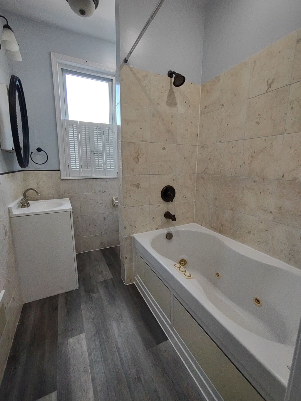 a bathroom with a tub and a sink and a window