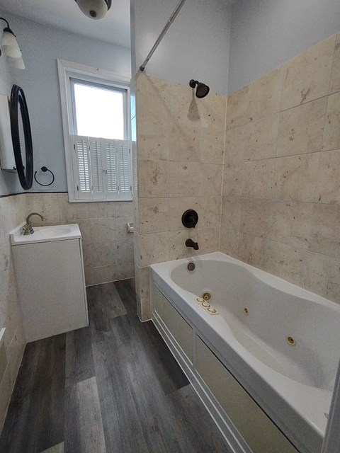 a bathroom with a tub and a sink and a window