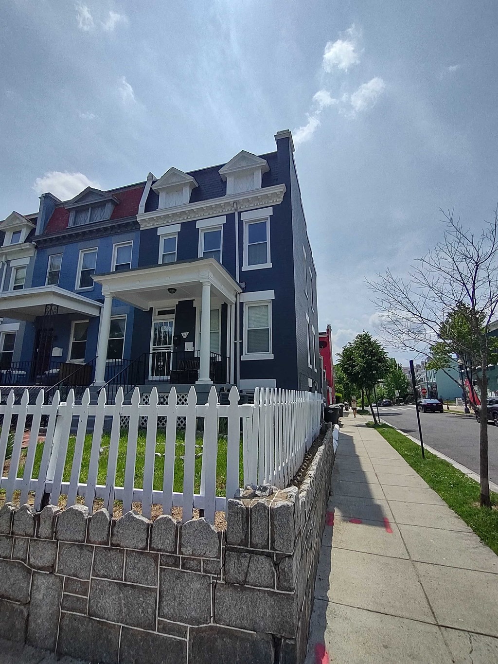 a blue house with a white fence in front of it