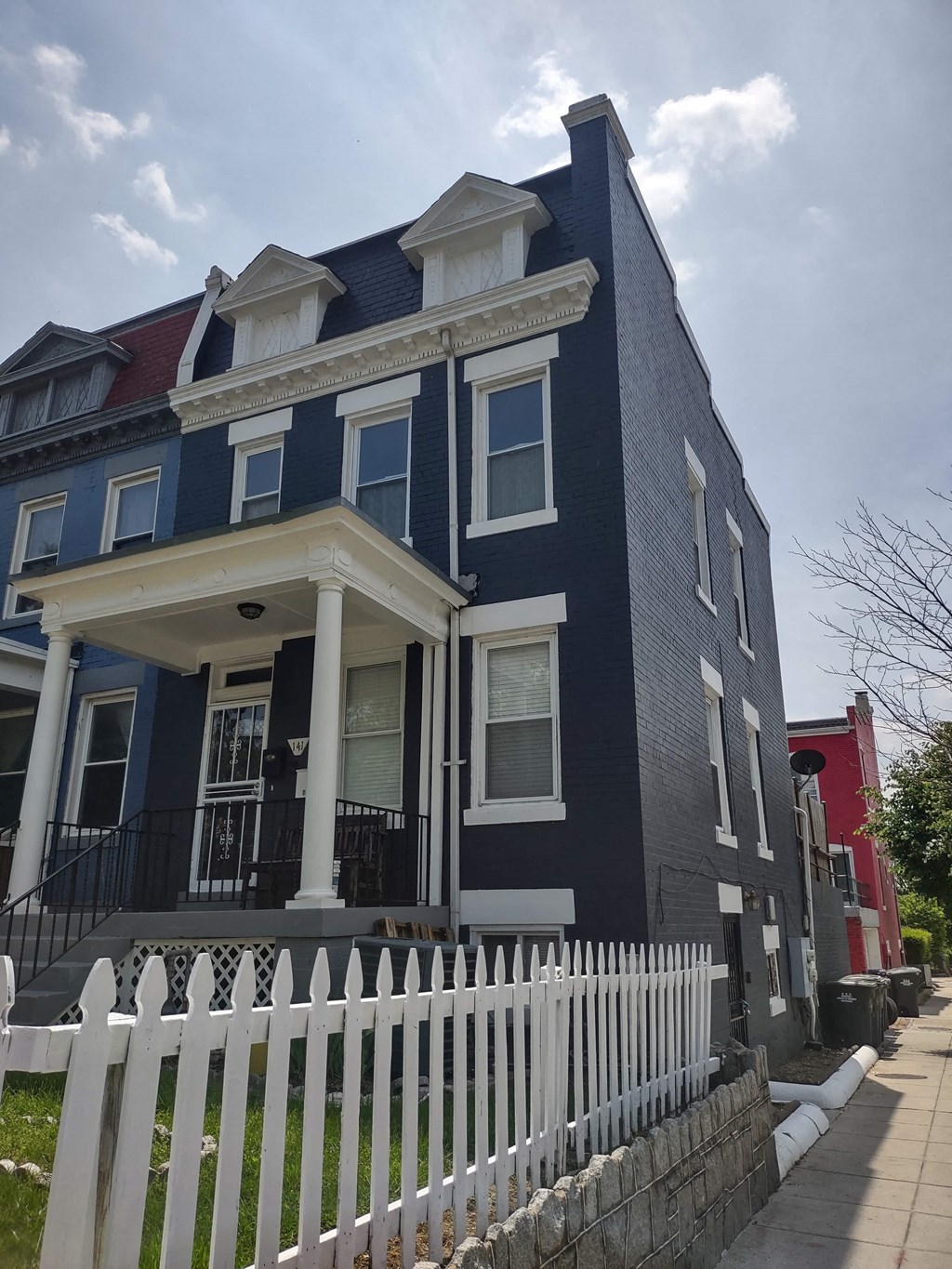 a blue house with a white fence in front of it