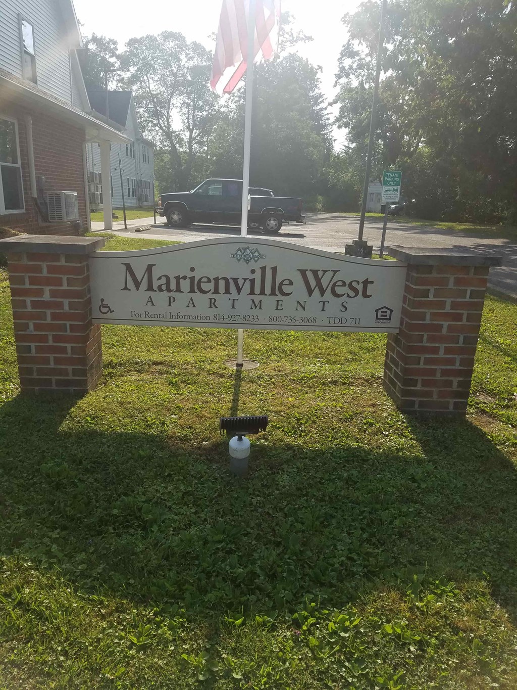 a street sign in front of a house with an flag