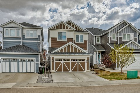 a row of homes with garages on a cloudy day