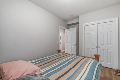a bedroom with a bed and two closet doors