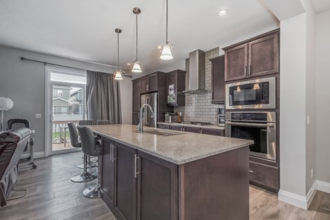 an open kitchen and living room with a large marble counter top