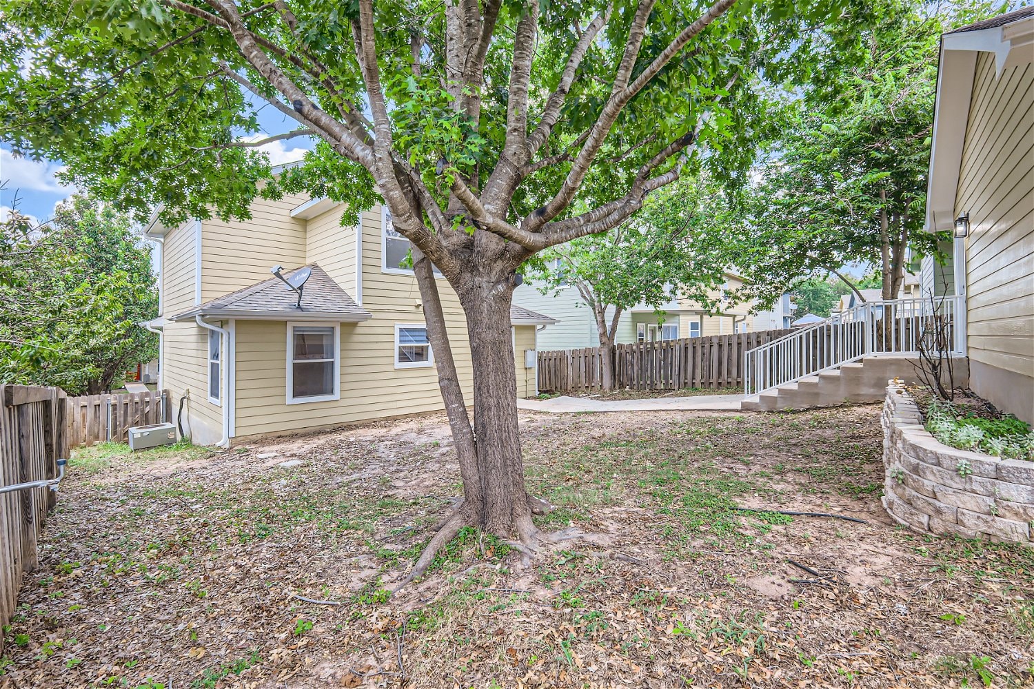 a yard with a tree in front of a house