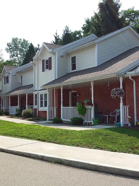 a red and white house with a porch and a sidewalk