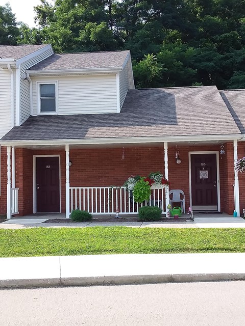 a red brick house with a porch and a porch swing