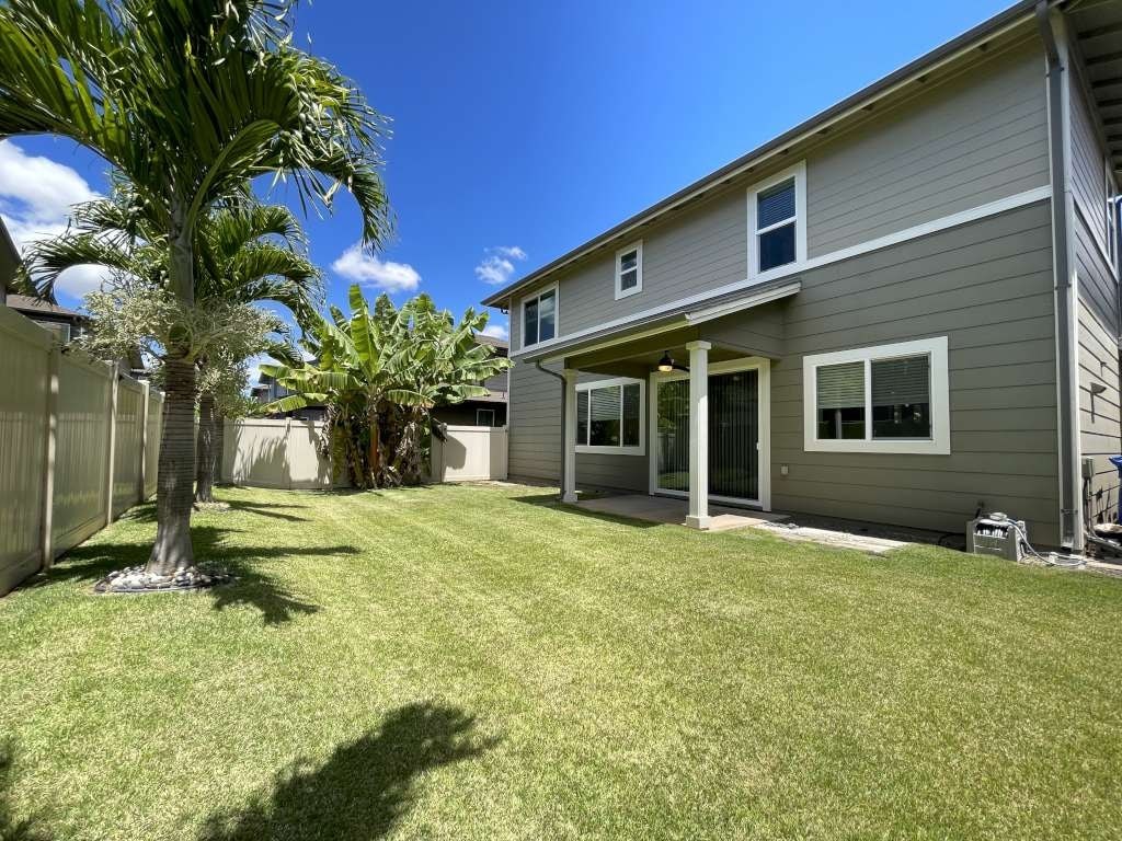 a backyard with a house and a palm tree