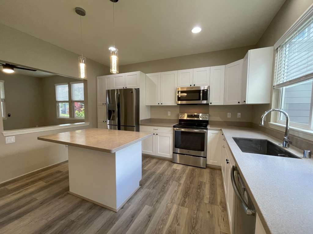 a kitchen with white cabinets and stainless steel appliances
