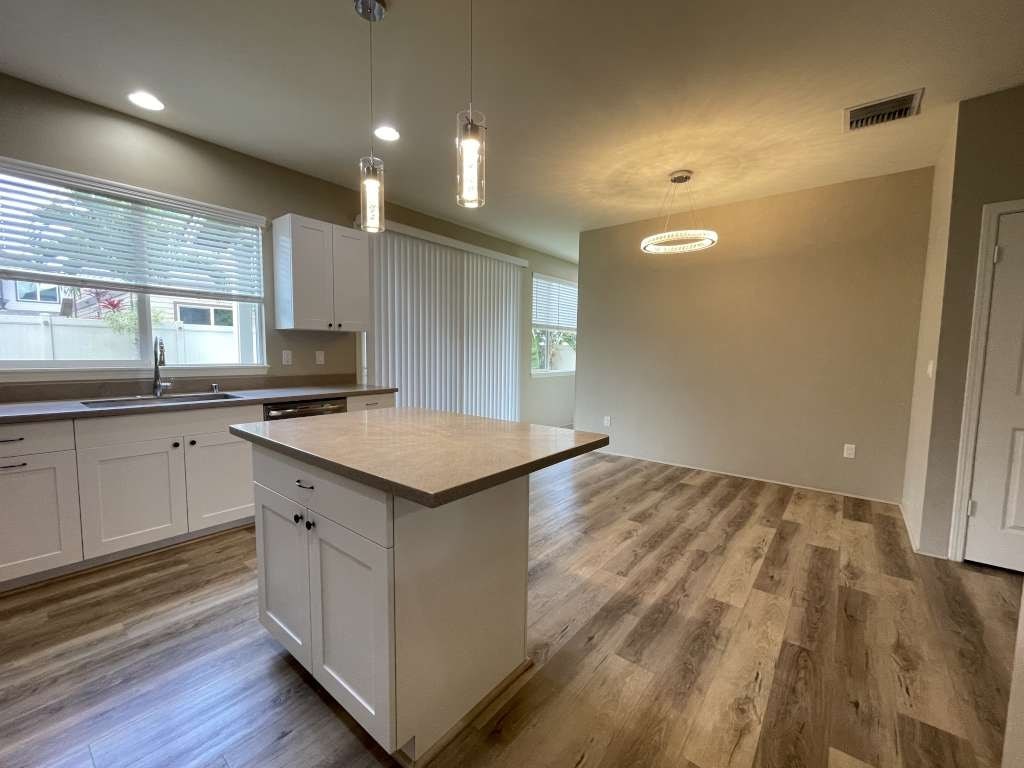 a kitchen with a center island and white cabinets