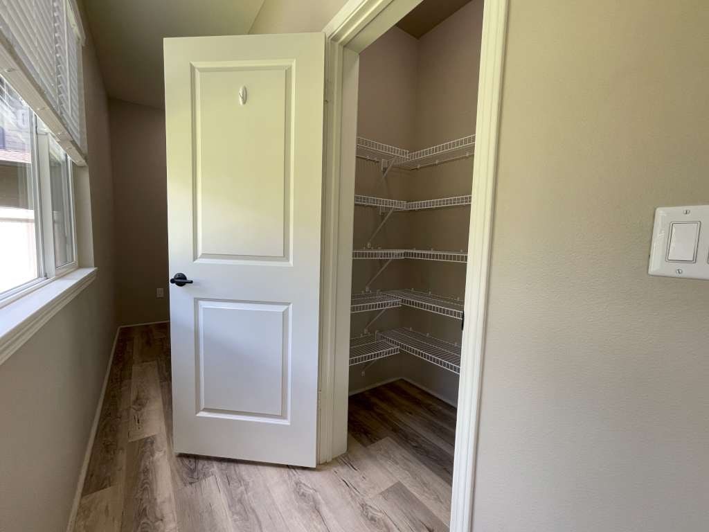 a small hallway with a white door and a closet
