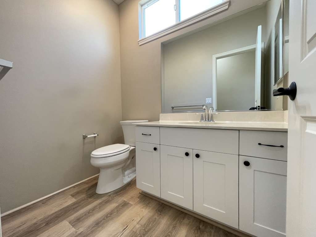 a bathroom with a toilet and a sink and a mirror