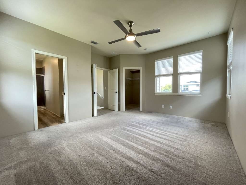 an empty living room with a ceiling fan