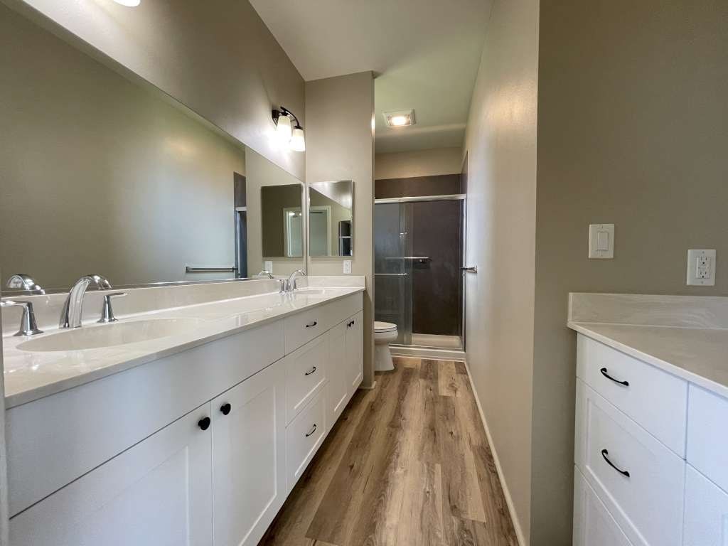 a large bathroom with two sinks and a shower
