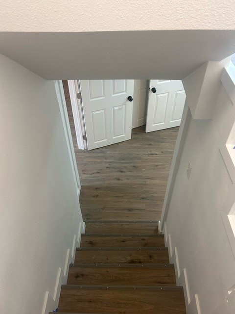 A staircase with wooden steps and white walls.