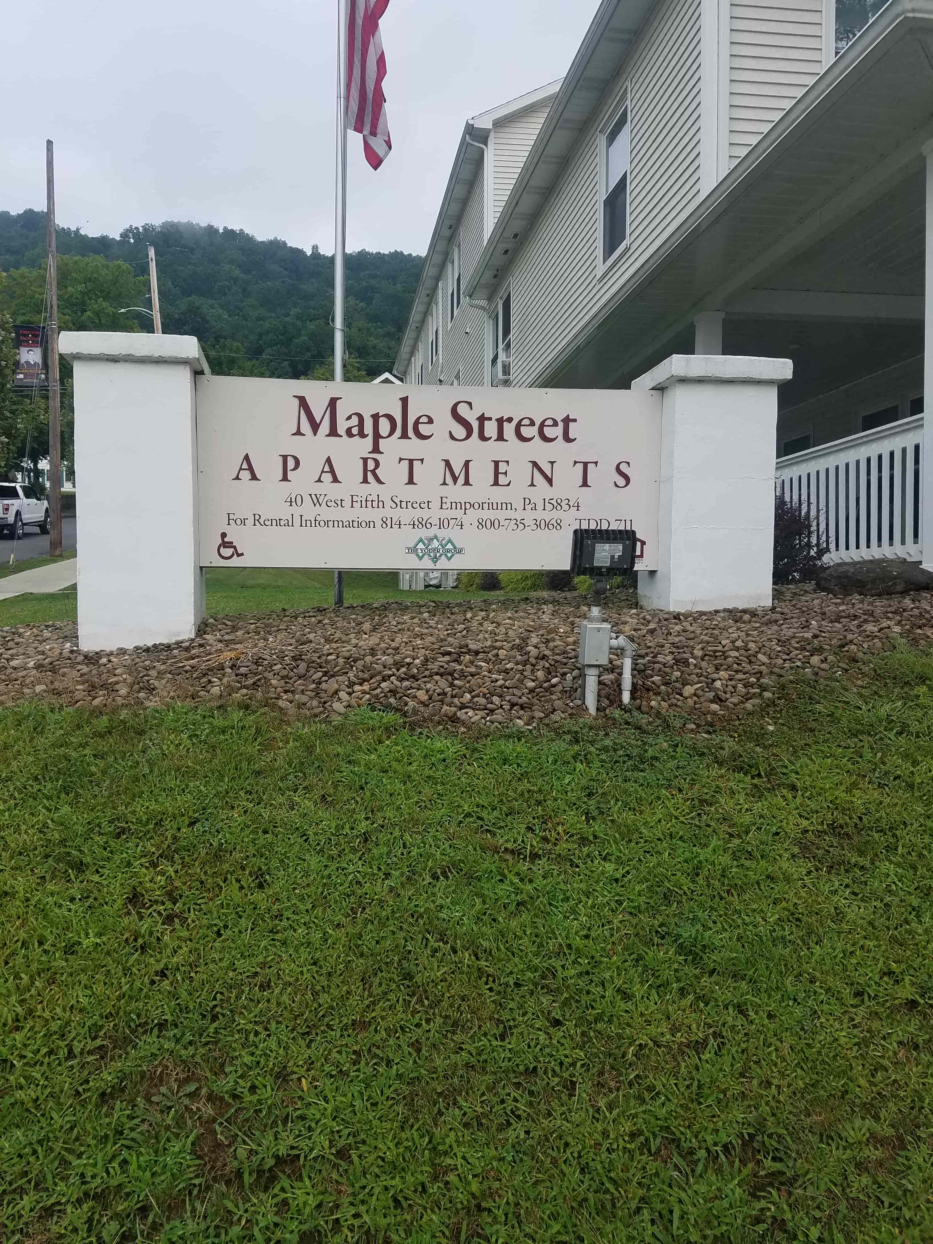 a sign for maple street apartments in front of a building