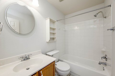 A white bathroom with a sink, toilet, and bathtub.