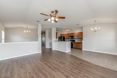 A spacious room with a ceiling fan and wooden flooring.