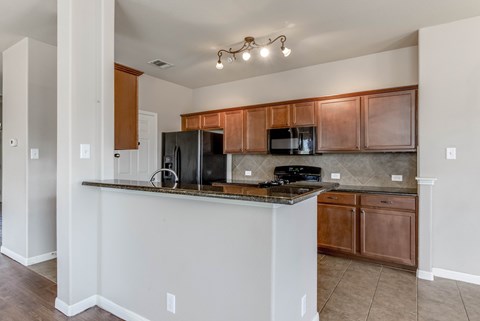 A kitchen with a white counter and brown cabinets.