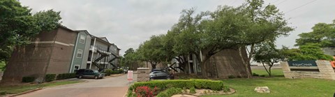 A car is parked in front of a building with a sign that says "Logic Creek.".
