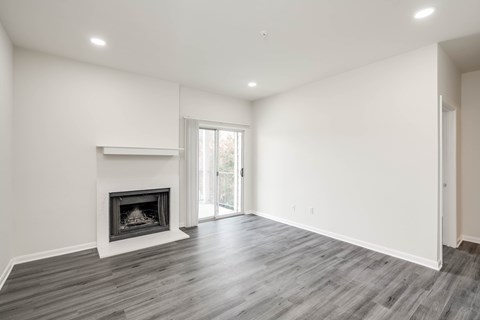 A spacious room with a fireplace and sliding glass doors.