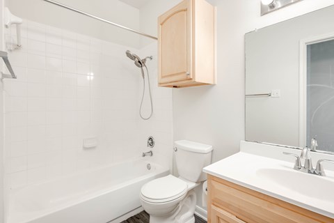 A white toilet sits next to a white sink in a bathroom.