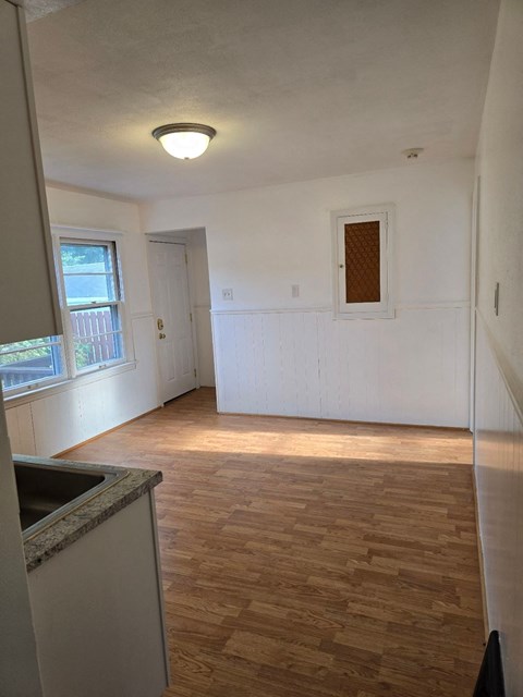 an empty kitchen and living room with a window