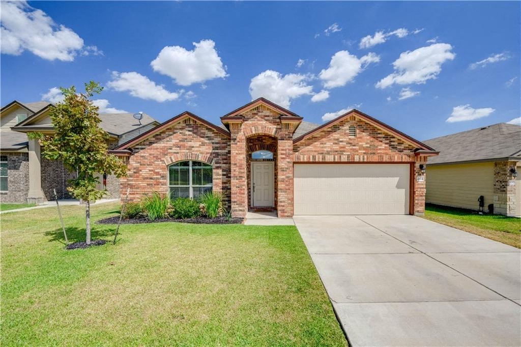a brick house with a driveway and a garage door