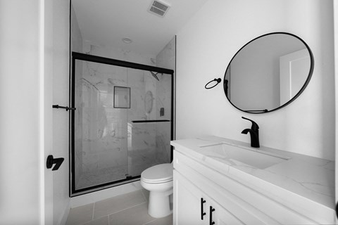 a bathroom with a shower and a sink and a mirror