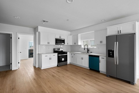 a kitchen with white cabinets and stainless steel appliances