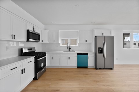 a kitchen with white cabinets and a stainless steel refrigerator