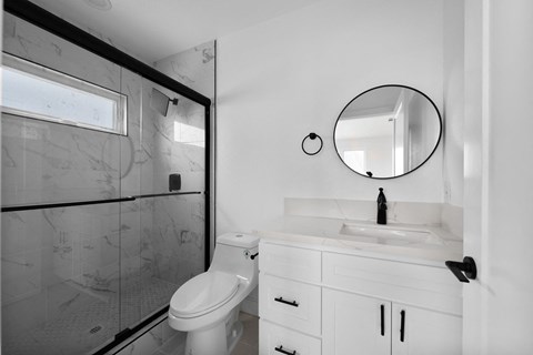 a white bathroom with a shower and a toilet and a sink