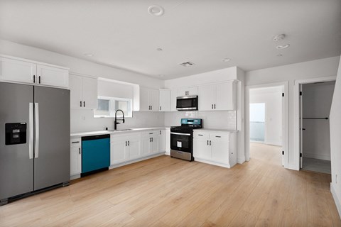 a kitchen with white cabinets and stainless steel appliances