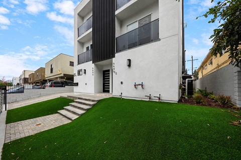 a white building with a green lawn in front of it