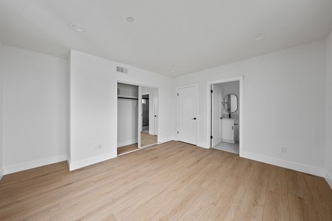 a renovated living room with white walls and wood floors