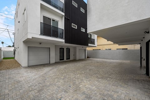 the courtyard of a new building with a driveway and a garage door