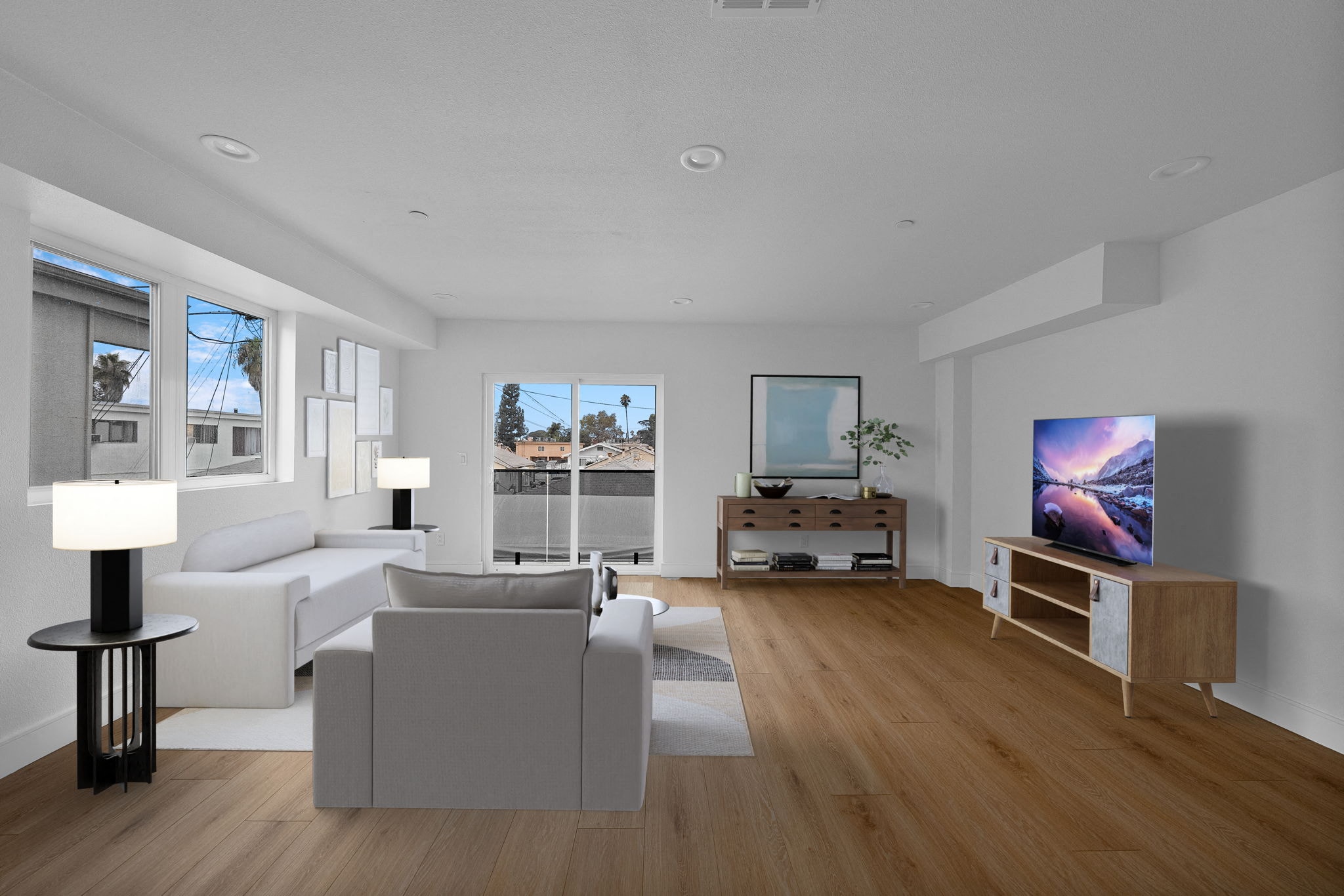 a living room with white couches and a television